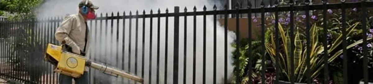 Mosquito control technician fogging a yard perimeter for mosquito reduction in Fargo, ND